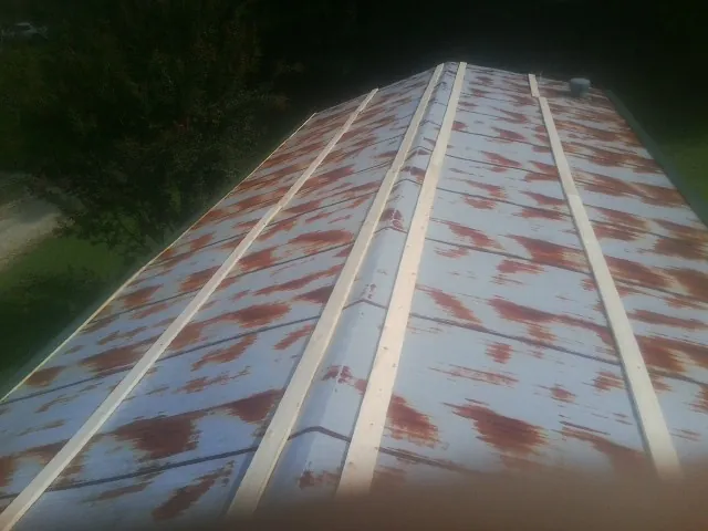 Rusted metal roof panels with new wood purlins before replacement — Storm Damage Roof Repair in Elmont by Roofing Brothers